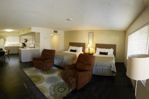 沙漠温泉丽都棕榈度假Spa酒店的酒店客房,配有两张床和两把椅子