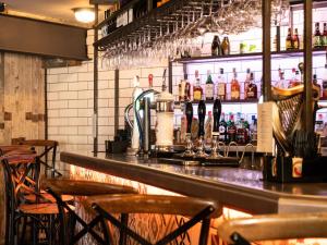 索厄比布里奇The Lion Pub & Grill的酒吧配有带椅子和酒瓶的吧台