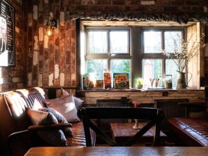索厄比布里奇The Lion Pub & Grill的一间配有沙发、桌子和窗户的客房