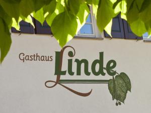 HofstettenGasthaus Linde的绿叶树丛边的标志