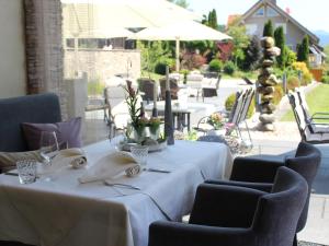 HofstettenGasthaus Linde的庭院里配有带白色桌布和椅子的桌子