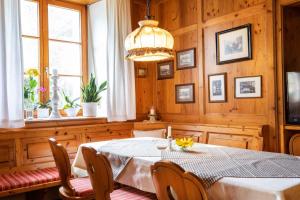 LauchheimLandgasthof Sonne的一间带桌椅和吊灯的用餐室
