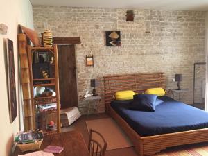 Ferrières阿卡西亚之家住宿加早餐旅馆的一间卧室设有一张大床和砖墙