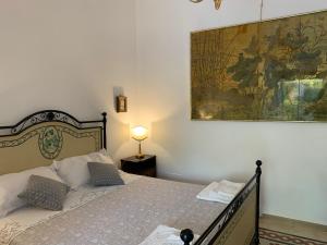 科拉托Farm Agriturismo Masseria Chiusurella的卧室配有一张床,墙上挂有绘画作品