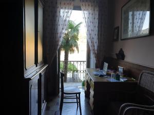 奥尔塔圣朱利奥La Casa dell'Isola的客房设有书桌和棕榈树窗户。