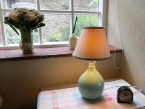BrastedThe Old Manor House B & B的坐在窗边桌子上的一盏灯