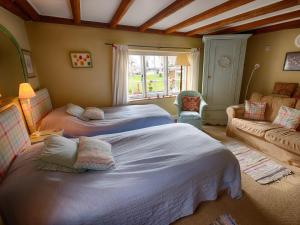 BrastedThe Old Manor House B & B的一间带两张床和一张沙发的卧室