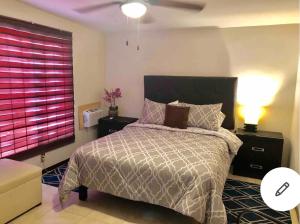 奇瓦瓦Agradable* y Cómodo Departamento Familiar (WiFi)的一间卧室配有一张床和一个粉红色的窗户