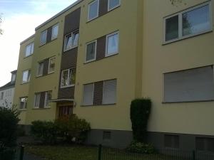 新基兴-弗卢因Fewo Neukirchen mit Balkon的黄色建筑,上面有百叶窗
