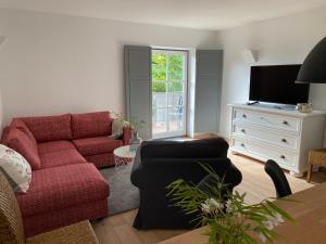 耶拿Gemütliches Domizil über den Dächern von Jena的客厅配有红色沙发和电视