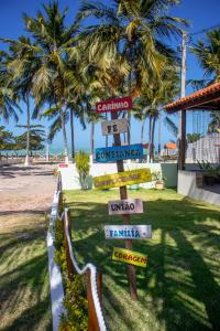 马拉戈日Parque dos Coqueiros- Bangalos e Suites的棕榈树海滩前的街道标志