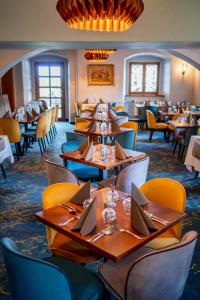 娄切尼卢森花园城堡酒店的餐厅设有木桌和黄色椅子