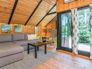 Øster Vrøgum4 person holiday home in Oksb l的客厅配有沙发和桌子