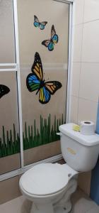 阿塔卡梅斯Hotel Internacional en Atacames的浴室设有卫生间,墙上挂有蝴蝶。