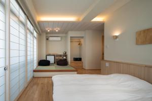 神户Arima Koyado Uraku的一间带白色床的卧室和一间厨房