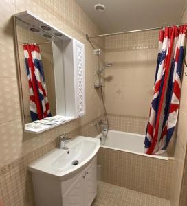 霍斯塔Отель "Золотой Лотос"的一间带水槽、浴缸和镜子的浴室
