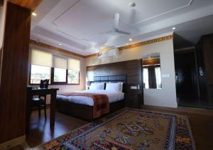 麦罗肯机Hotel Norbu House的酒店客房带一张床铺、一张书桌和一间卧室