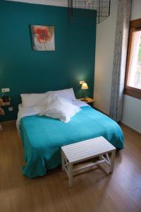 恩坎普Hotel Arbre De Neu的一间卧室配有一张蓝色的床,旁边设有长凳