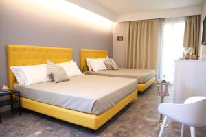 特罗佩阿J Luxury Home的配有黄色床的酒店客房的两张床