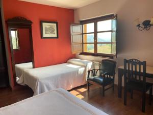 VillayónHotel Rural Yeguada Albeitar的一间卧室设有两张床、一张桌子和一个窗口。