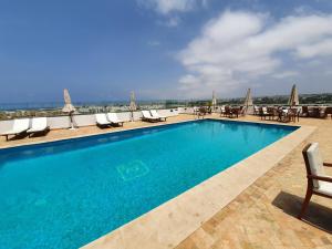 拉巴特Hotel Rabat - A member of Barceló Hotel Group的大楼内一个带桌椅的游泳池