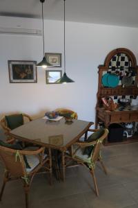 卡门港Casa Arrigo - Splendido bungalow centrale con grande terrazza e vista mare的一间带木桌和椅子的用餐室
