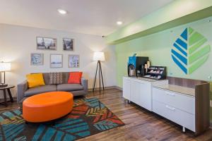 达文波特WoodSpring Suites Davenport Quad Cities的客厅配有沙发和电视。