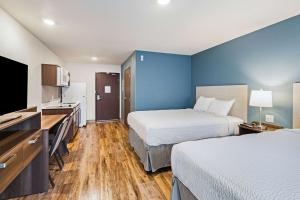达文波特WoodSpring Suites Davenport Quad Cities的酒店客房设有两张床和一台平面电视。