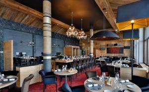 葱仁谷Hôtel Koh-I Nor by Les Etincelles的餐厅设有桌椅和吊灯。