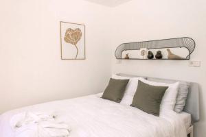 赞德沃特The Pine Tree House的白色卧室配有白色床和绿色枕头