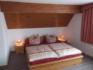 特劳泰斯腾Pension Waldhof的一间卧室配有一张带两盏灯的木床。