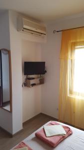 科托尔Apartmani Račeta的一间卧室设有一张床、一台电视和一个窗口。