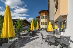 瓦格赖恩埃里卡漫游酒店的庭院配有桌椅和黄色遮阳伞