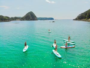 下田Guesthouse All you need的一群人,在水面上冲浪板上