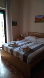 雷焦卡拉布里亚La Casa di Aurora的一间卧室配有一张大床和毛巾