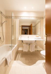 莱维科特尔梅伊甸酒店的一间带水槽、浴缸和卫生间的浴室