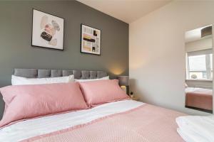 诺丁汉Blackstone Walk - Fabulous Houses with Parking的卧室配有粉红色的床,墙上挂有两张照片