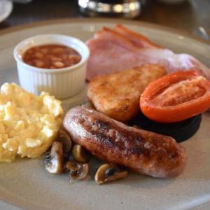 Kentisbury肯提斯波利格兰格酒店的包括香肠鸡蛋培根和蘑菇的早餐食品