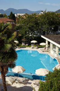 阿巴诺泰尔梅水上酒店的一个带遮阳伞的大型蓝色游泳池