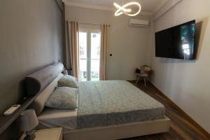 雅典Double Romantic Suite的一间卧室配有一张床和一台平面电视
