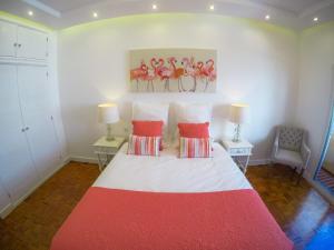 法鲁Luxury Flat in Faro的卧室配有红色和白色的床和两张桌子