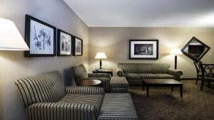 斯普林代尔斯普林代尔费耶特维尔地区假日酒店的酒店客房设有一间带两张沙发和椅子的客厅