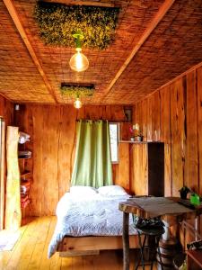 埃雷迪亚Cabaña Mountain View的木制客房内的一间卧室,配有一张床