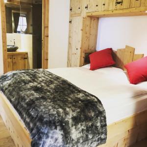 AlveraCiasa Coletin的一间卧室配有一张带红色枕头的木床。