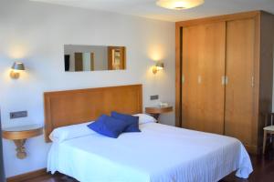 坎加斯-德奥尼斯伊尔塞拉酒店的卧室配有带蓝色枕头的大型白色床