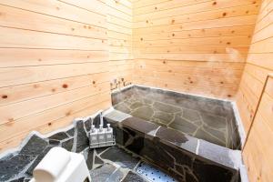 由布市YUFU-Inn プライベートな露天風呂付き-由布院駅徒歩2分-最大8名宿泊可能的木墙内带浴缸的浴室
