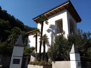 坎诺比奥Marenca Residence的一座白色的建筑,前面有棕榈树