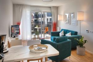 塞尔吉Domitys - Galilée的客厅配有蓝色的沙发和桌子