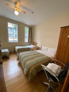 伦敦Seven Dials Hotel Annexe的一间卧室配有两张床和椅子
