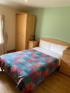 伦敦Seven Dials Hotel Annexe的一间卧室,床上有五颜六色的被子